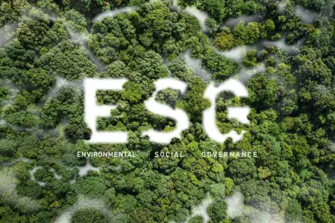 Foresta lussureggiante con la scritta "ESG" in bianco, che simboleggia investimenti ESG. Sotto, le parole "Environmental, Social, Governance".
