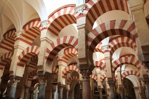 Las icónicas partes de la mezquita de Córdoba: arcos de herradura bicolores y columnas que crean un laberinto arquitectónico.
