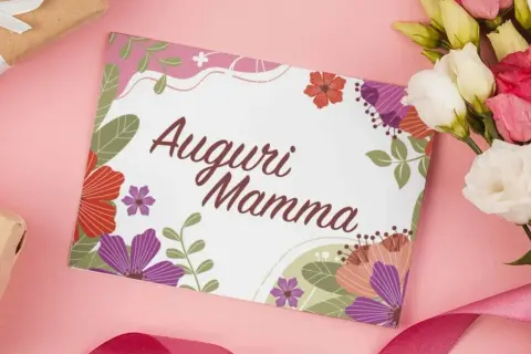Un biglietto con scritto "Auguri Mamma" circondato da fiori colorati, un mazzo di fiori e pacchi regalo. Un modo per dire perché si festeggia la festa della mamma.