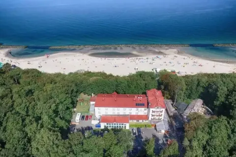 Tanie noclegi Darłówko: hotel otoczony lasem, blisko plaży pełnej turystów. Idealne miejsce na wakacje nad morzem.