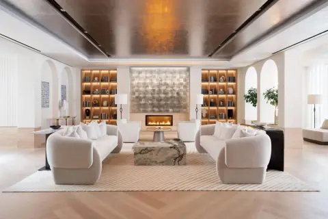 A luxurious living room designed by top interior designers, featuring plush sofas, a modern fireplace, and elegant built-in shelving.