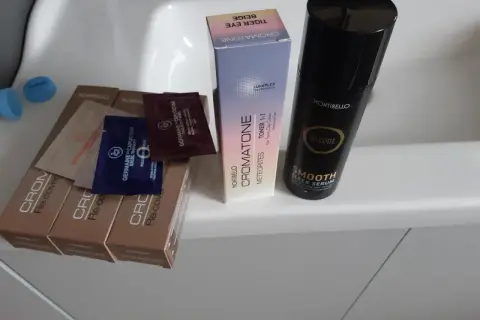 Butelka serum Montibello Smooth Sleek Serum, pudełko z tonerem do włosów Cromatone i próbki kosmetyków.