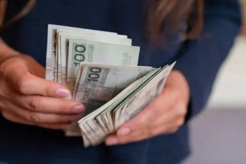 Dłonie liczą banknoty 100 zł. Czy to tyle, ile zarabia aktor w Ukrytej Prawdzie?
