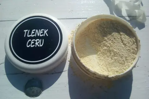 Puszka z napisem "TLENEK CERU" obok otwartego pojemnika z żółtym proszkiem.
