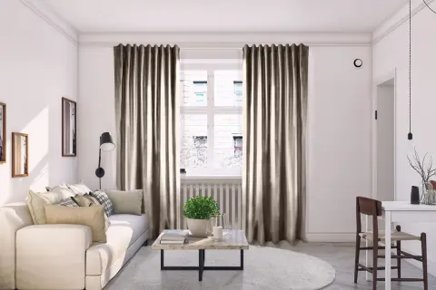 Mysig vardagsrumsmiljö med beiga sammetsgardiner som ger perfekt gardin inspiration. En vit soffa och ett runt soffbord skapar en inbjudande känsla.
