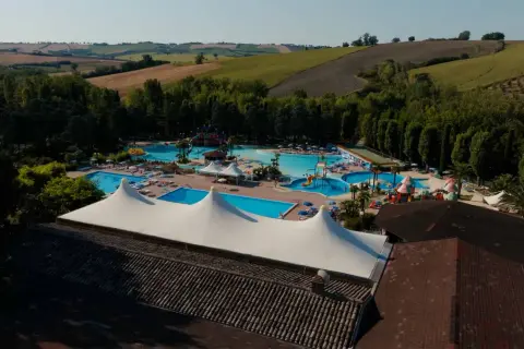 Vasta area con piscine, scivoli e aree relax nel parco acquatico di Cingoli, immerso nel verde delle colline marchigiane.