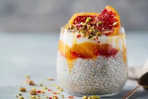 En läcker chiapudding med kvarg, apelsin och blodapelsin, toppad med pistagenötter.