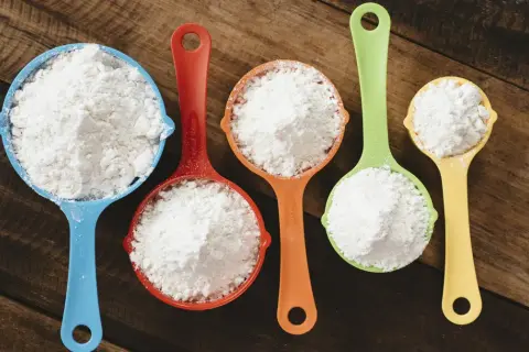 Mätkoppar med mjöl, redo att byta vetemjöl mot glutenfritt för bakning.