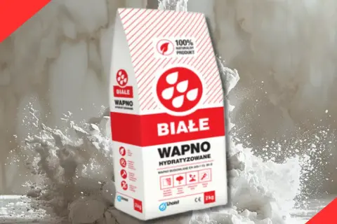 Białe wapno hydratyzowane w worku, otoczone chmurą pyłu. Idealne do budowy i tynkowania.
