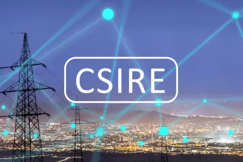 Sieć energetyczna miasta nocą, z liniami przesyłowymi i neonowym napisem "CSIRE".