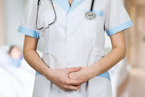 Een verpleegkundige met stethoscoop, klaar om zorg te verlenen. De sfeer doet denken aan het Florence Nightingale syndroom, waar empathie en toewijding centraal staan.