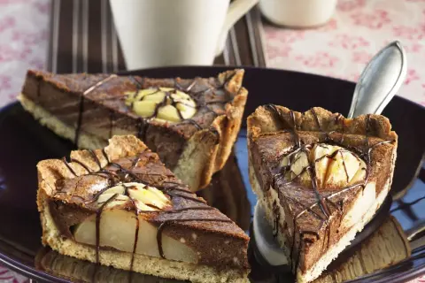 Drei Stücke saftiger Birnen Schoko Kuchen auf einem Teller, verziert mit Schokoladenglasur und Birnenstücken.