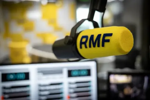 Mikrofon studyjny RMF z żółtym futerkiem i niebieskim logo.