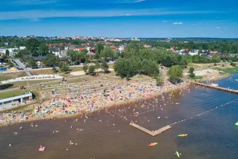 Tłoczna plaża nad zalewem w Starachowicach, pełna ludzi kąpiących się i opalających. Idealne starachowice atrakcje dla dzieci i dorosłych w słoneczny dzień.