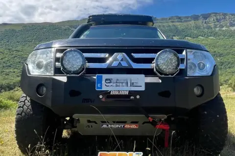 Mitsubishi Montero V80 preparado para aventura, con parachoques reforzado, focos potentes y techo solar.