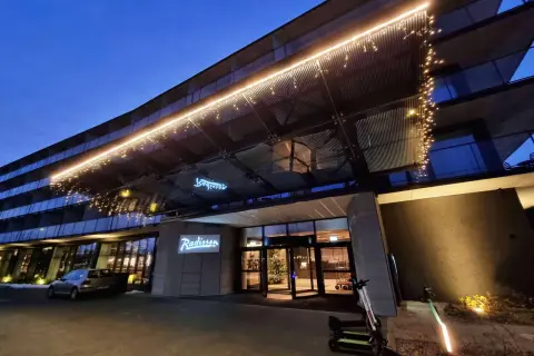 Wejście do hotelu Radisson Resort Kołobrzeg nocą, ozdobione lampkami.