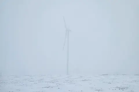 Wiatr huczy jak wiersze o smutku i żalu. Samotna turbina na zaśnieżonym polu, w mglistym, przygnębiającym krajobrazie.