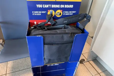 Torba podróżna w niebieskim boksie kontrolnym Ryanair. Sprawdź, czy Twoja torba spełnia wymiary, by uniknąć dodatkowych opłat za bagaż.