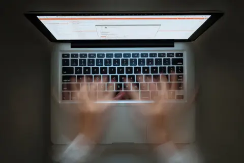 Ręce szybko piszą na klawiaturze laptopa. Widać ekran z kodem. Szybkie pisanie to jak zaznacz wszystko skrót.
