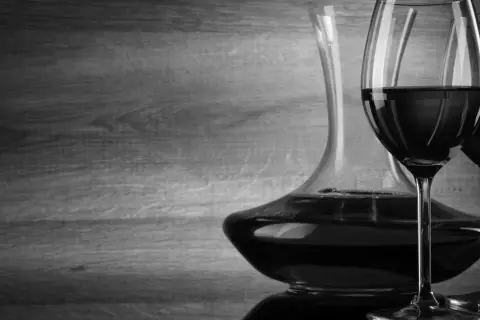 Caraffa e due calici di vino rosso, con un'atmosfera che evoca un buon cannellino di Frascati.