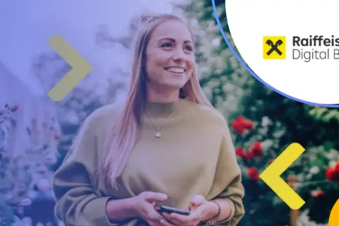 Uśmiechnięta kobieta z telefonem w ręku, korzystająca z usług Raiffeisen Digital Bank.