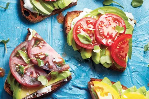 Tartines gourmandes : une recette avocat simple et savoureuse avec tomates fraîches et pousses croquantes sur pain grillé.
