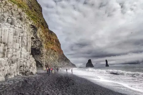 Słynna plaża Reynisfjara z bazaltowymi kolumnami i skalnymi formacjami w morzu.