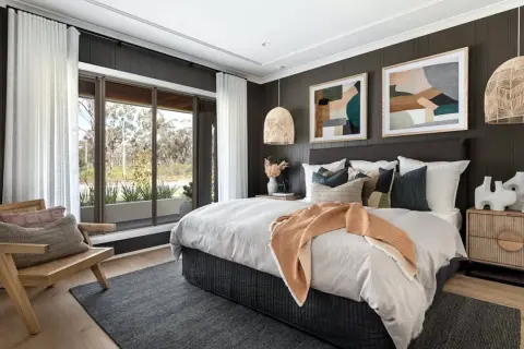 Light wood nightstands complement the dark wood bed. A cozy bedroom with a large window, rattan chair, and abstract art.