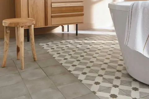 Un sol de salle de bain avec deux types de carrelage : un uni gris et un à motifs géométriques. Une idée pour peindre carrelage sol et moderniser une pièce.