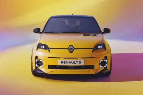 Żółty Renault 5 e-tech z czarnym dachem, nowoczesnymi światłami i napisem "RENAULT 5" na tle tęczowego gradientu.