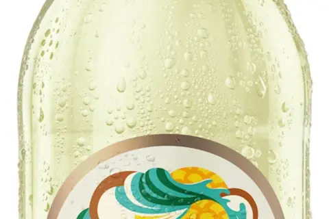 Schłodzona butelka Somersby Pina Colada, pokryta kroplami rosy, z etykietą w tropikalne wzory.