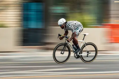 Dynamic racing photography captures a cyclist in motion, blurring the background to emphasize speed.