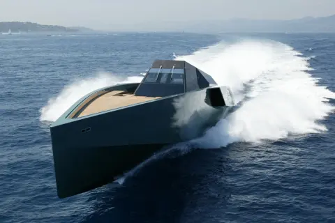 Un elegante yacht, forse quello di Gianluca Vacchi, sfreccia sull'acqua blu, lasciando una scia bianca.