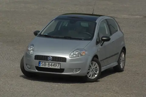 Srebrny Fiat Punto z czarnym dachem i przyciemnianymi szybami, z widocznymi światłami.
