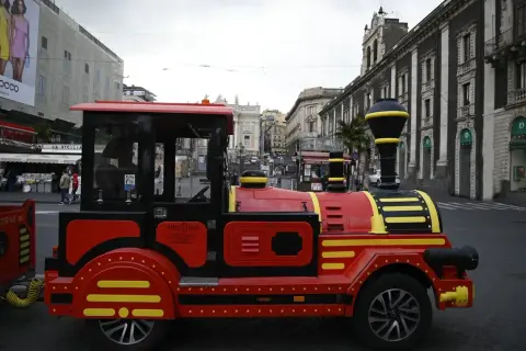 Czerwony pociąg turystyczny na ulicach Katanii Syrakuzy, idealny do zwiedzania.