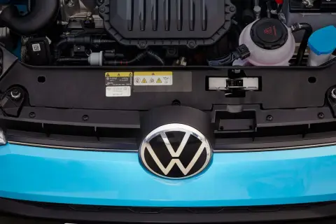 Motorutrymmet på en blå Volkswagen. En etikett visar information om olja och kylvätska, vilket kan vara relevant vid ett volkswagen gasbil problem.