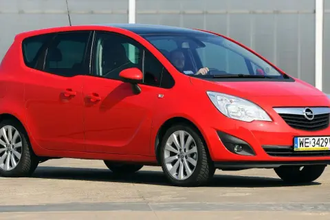 Czerwony Opel Meriva 1.6 benzyna z czarnym dachem, zaparkowany na zewnątrz.