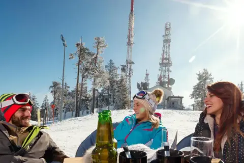 Trzech narciarzy cieszy się słońcem i piwem na stoku. Czy piwo może stać na mrozie? Tak, jeśli jest zimne!