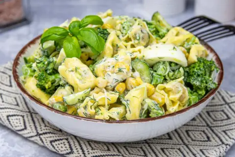 Pyszna sałatka z tortellini, brokułów, kukurydzy, ogórka i jajka w kremowym sosie.