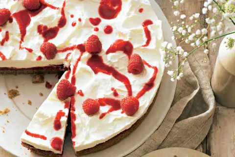 Himbeer Sahne Torte mit frischen Beeren und rotem Fruchtpüree, ein Genuss für Augen und Gaumen.