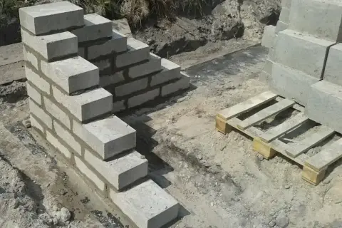 Budowa schodów z bloczków betonowych, gdzie zaprawa murarska do bloczków betonowych spaja kolejne warstwy.