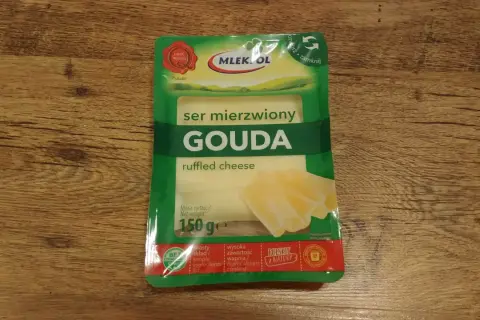 Opakowanie sera Gouda z widocznymi plasterkami sera i informacją o wadze 150g.