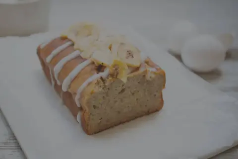 Ein saftiges Bananenbrot ohne Zucker, verziert mit Zuckerguss und Bananenchips. Perfekt für einen gesunden Genuss.