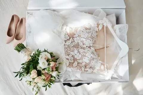 Brautkleid, Schleier, Brautstrauß und zarte Pumps liegen bereit. Alles für das Getting ready Hochzeit.