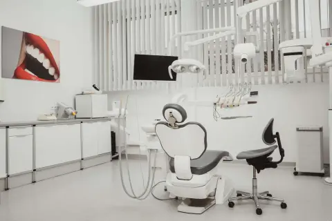 Nowoczesny gabinet stomatologiczny z fotelem dentystycznym i sprzętem.