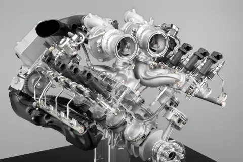 Detaljerad vy av en BMW V8-motor med dubbelturbo. Synliga kolvar, vevaxel och insprutningssystem.