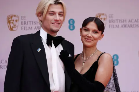 Millie Bobby Brown y su pareja, Jake Bongiovi, posan sonrientes en la alfombra roja de los BAFTA.