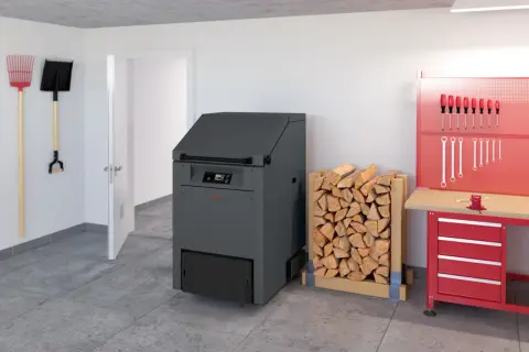 Holzstapel neben einem modernen Heizkessel, der bald dem Festbrennstoffkessel Verbot zum Opfer fallen könnte. Werkzeuge hängen an der Wand.