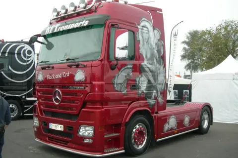 Camion rouge customisé avec une pin-up, un style tuning déf.