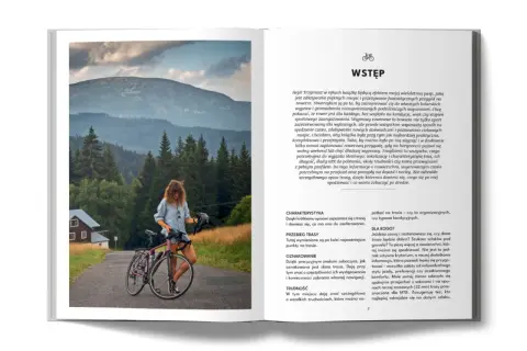 Kobieta z rowerem na tle gór i lasów. Planujesz rowerem na Hel? Ta książka pomoże Ci w podróży.